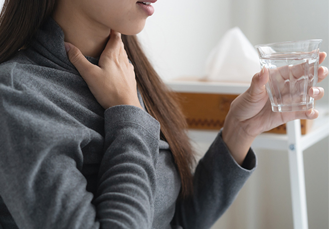 Abbildung Frau mit Halsschmerzen, die sich an den Hals greift